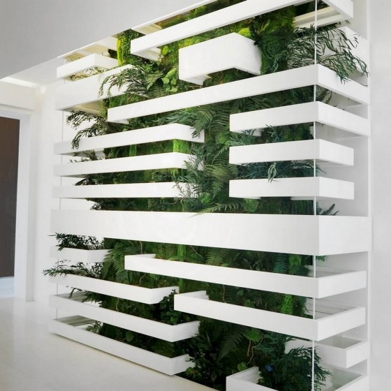 Mur végétal très dense installé sur mesure derrière une structure métallique et claustra d'architecte blanc.