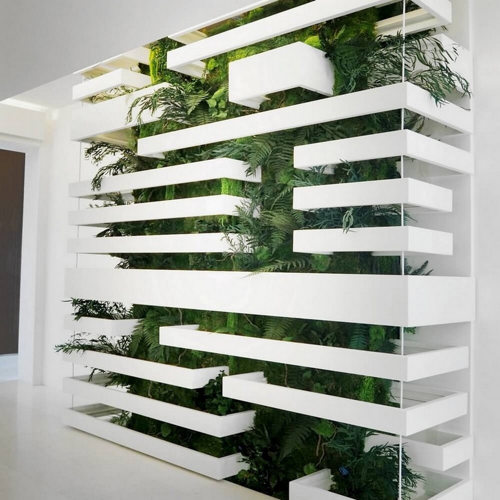 Mur végétal très dense installé sur mesure derrière une structure métallique et claustra d'architecte blanc.