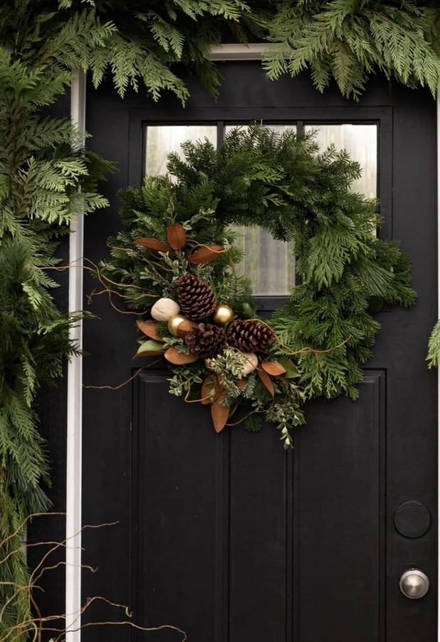 couronne de noel sur une porte en juniperus , pomme de pin et feuillage automnale