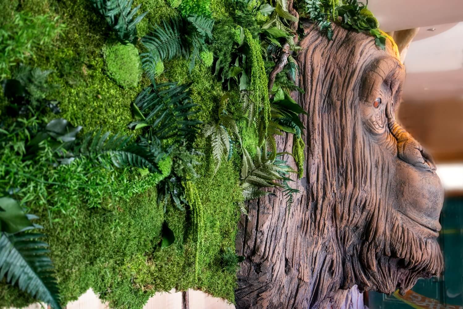 Mur végétal stabilisé avec grande tête de singe décorative de profil