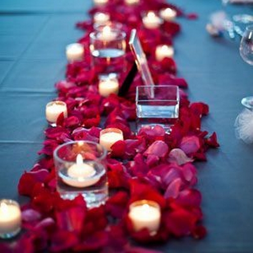 Table de réception de mariage avec bougies et pétales rouges