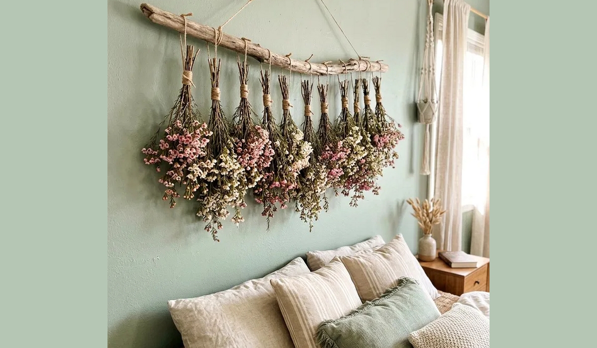Guirlande de bouquets de fleurs séchées accrochés au mur au-dessus d’un canapé