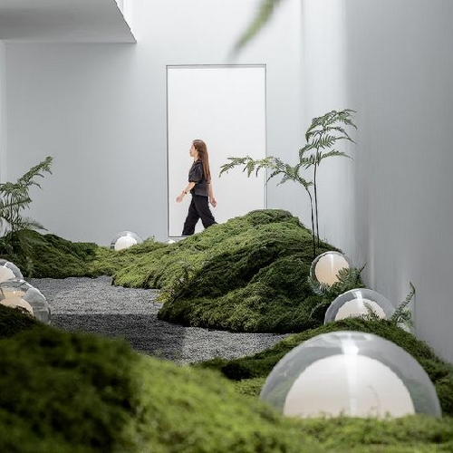 Installation de design végétal avec tapis de mousse et dômes blancs dans un espace intérieur