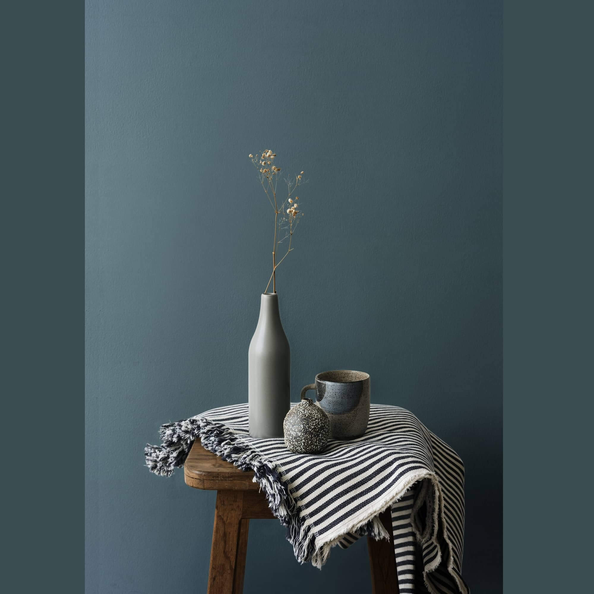vases gris posé sur un petite table en bois mur de couleur bleuté