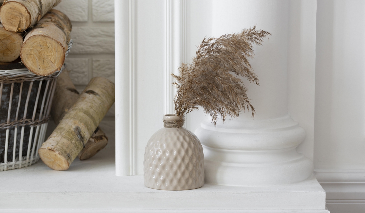 bouquet de pampa naturel séchée dans un vase beife devant une colonne de cheminée