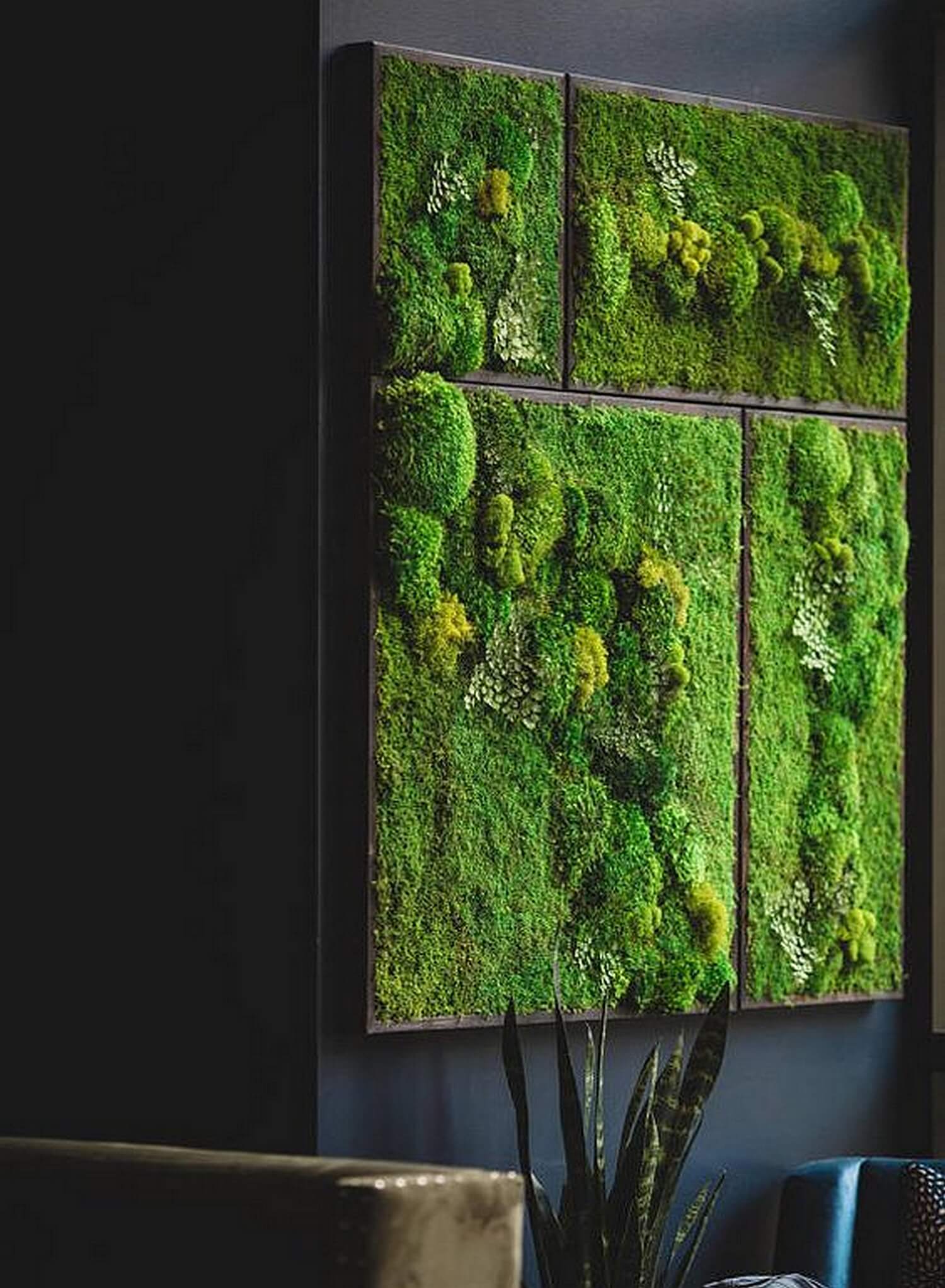 Tableau végétal stabilisé accroché au mur au-dessus d’un meuble dans un salon