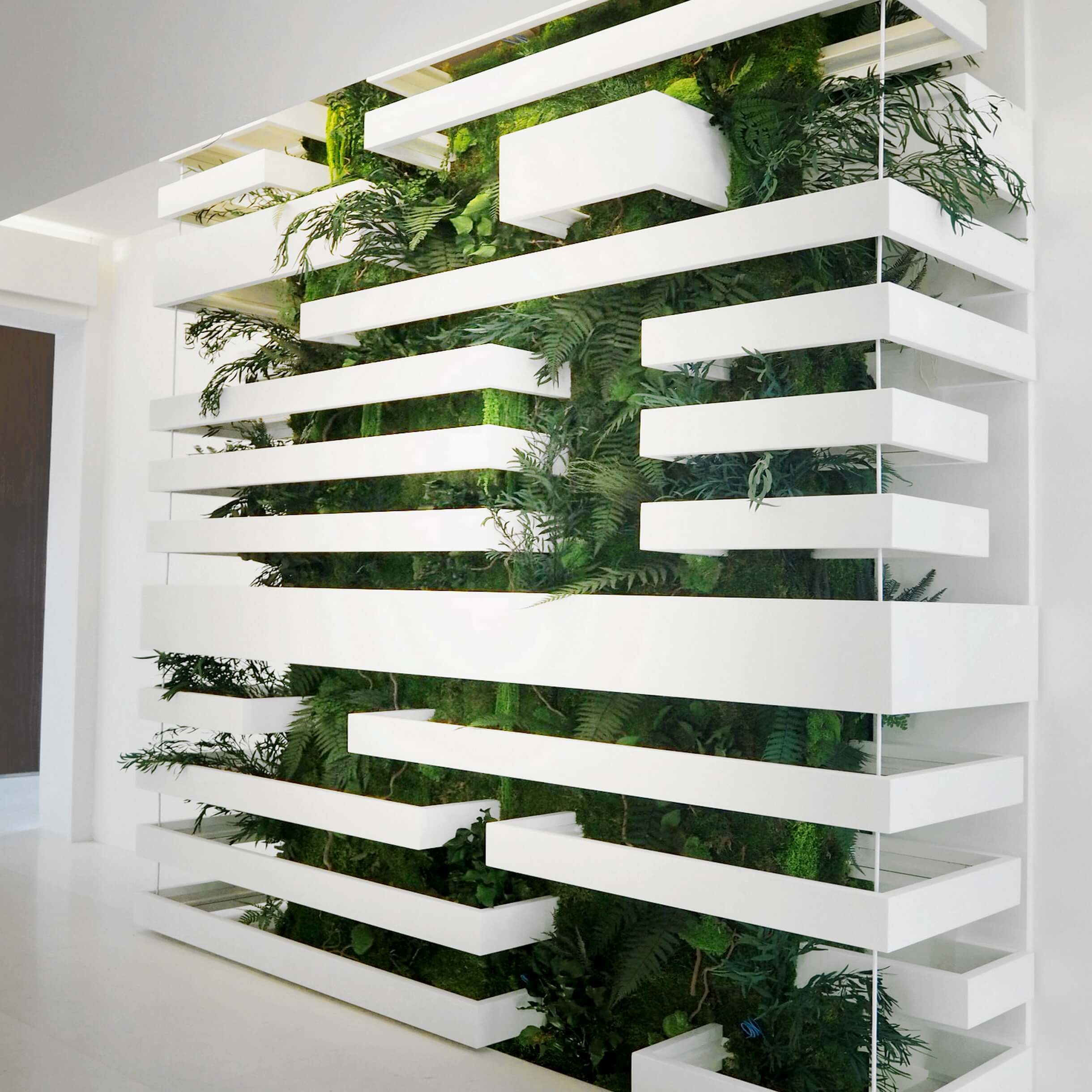 Grand mur végétal stabilisé intégré dans une structure design en métal blanc